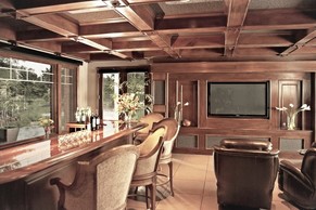 Traditional luxury home theater and bar with custom millwork and coffered ceilings.